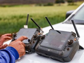Agricultores usam controles de drone para monitorar uma propriedade rural e apoiar decisões de agricultura de precisão.
