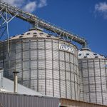 Silos industriais de grãos em Paragominas, no Pará, sob céu azul.